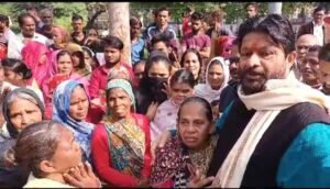 बेघर हुए लोग बैठे धरने पर